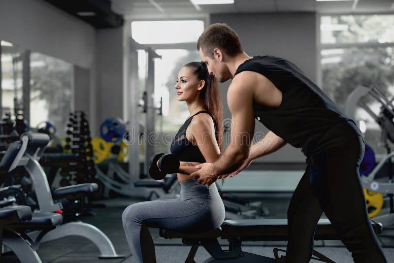 Personal trainer coaching a client in the gym